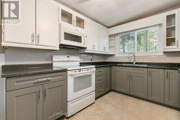 Tillsonburg apartment for rent - A kitchen with a white stove top oven and white cabinets.