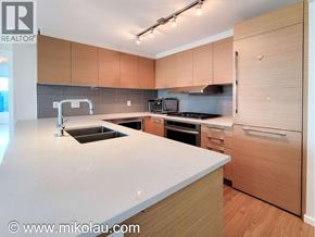 Burnaby apartment for rent - A modern kitchen with wooden cabinets and a white countertop.