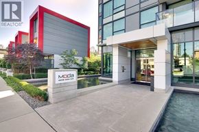 Burnaby apartment for rent - A modern building with a pool in front and a sign that says "MODA".