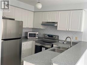 Mississauga (East Credit) townhouse for rent - A kitchen with white cabinets and a stainless steel refrigerator.