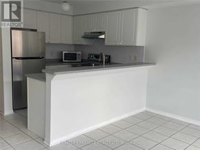Mississauga (East Credit) townhouse for rent - A kitchen with white cabinets and a stainless steel refrigerator.
