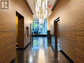 Toronto (Bay Street Corridor) condo for rent - A hallway with wood paneling and a chandelier.