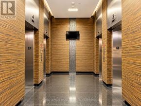 Toronto (Bay Street Corridor) condo for rent - A hallway with wooden walls and a flat screen TV mounted on the wall.