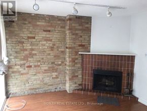 Toronto (Annex) apartment for rent - A room with a brick wall and a fireplace.