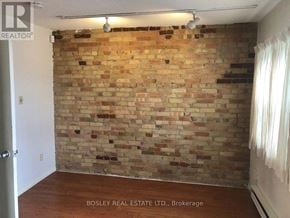 Toronto (Annex) apartment for rent - A room with a brick wall and wooden flooring.