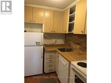 Toronto (Annex) apartment for rent - A kitchen with wooden cabinets and a white fridge.