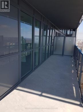 Toronto (Bay Street Corridor) condo for rent - A balcony with glass doors and windows overlooking a cityscape.