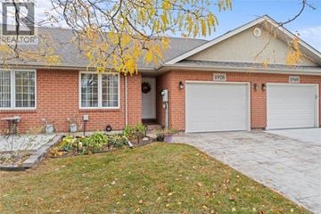 Windsor townhouse for rent - A house with a garage and a tree with yellow leaves in front.
