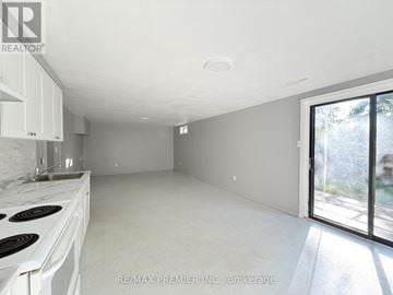 Barrie (Letitia Heights) duplex for rent - A white kitchen with a stove top oven and a window.