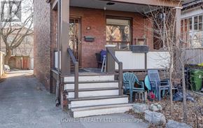 Toronto (High Park North) triplex for rent - A house with a porch and a small garden.