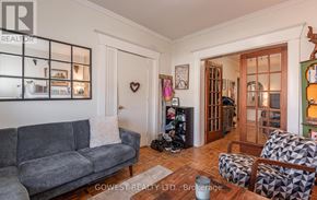 Toronto (High Park North) triplex for rent - A living room with a grey couch and a wooden floor.