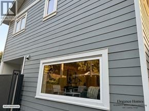 Vancouver apartment for rent - A grey house with a white window and a sign that says Elegance Homes.