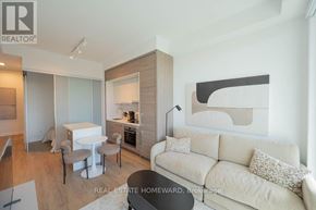 Toronto (Bayview Village) condo for rent - A modern living room with a white sofa and a dining table.