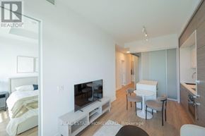 Toronto (Bayview Village) condo for rent - A modern bedroom with a large bed and a television.