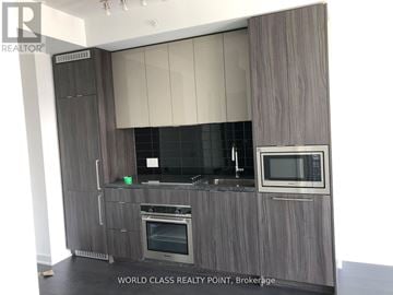 Toronto (Waterfront Communities) condo for rent - A modern kitchen with a grey cabinetry and stainless steel appliances.