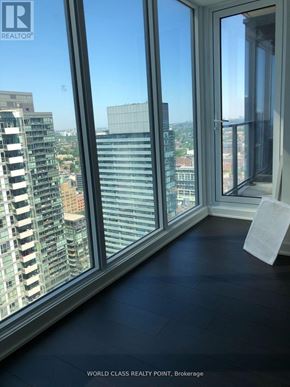 Toronto (Waterfront Communities) condo for rent - A real estate listing photo of a large glass room with a view of the city.