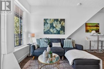 St. Catharines (E. Chester) apartment for rent - A living room with a blue couch and a painting on the wall.