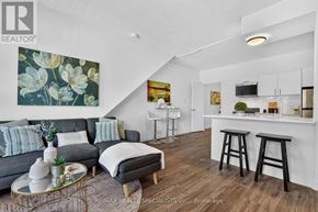 St. Catharines (E. Chester) apartment for rent - A living room with a grey couch, a coffee table, and a painting on the wall.