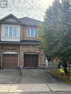 Mississauga (Hurontario) apartment for rent - A house with a garage and a tree in front.