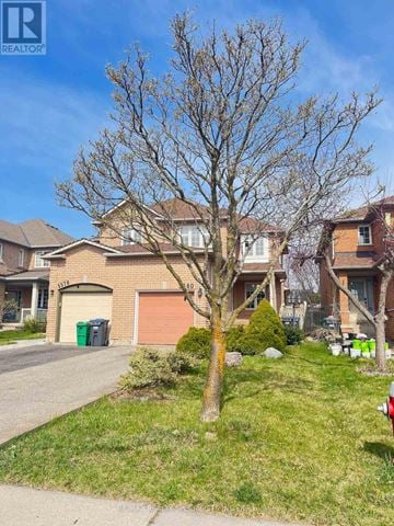 Mississauga (Central Erin Mills) apartment for rent - A tree in front of a house with a garage door.