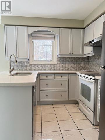 Mississauga (Central Erin Mills) apartment for rent - A kitchen with white cabinets and a tiled backsplash.