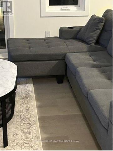 Cobourg townhouse for rent - A grey couch with a pillow on it in a living room.