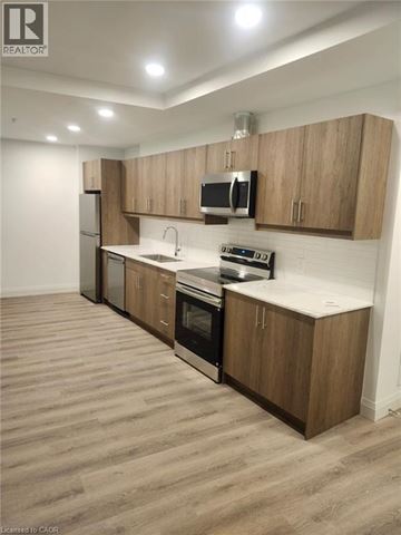 Kitchener condo for rent - A kitchen with wooden cabinets and a white countertop.