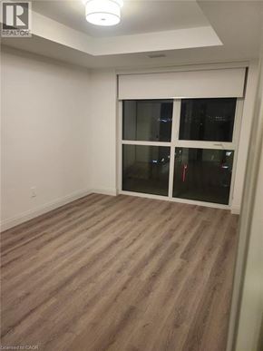 Kitchener condo for rent - A room with a sliding glass door and wood flooring.