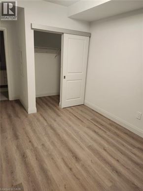 Kitchener condo for rent - A room with a white door and wood flooring.
