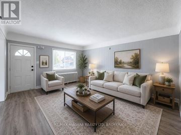Niagara Falls (Clifton Hill) apartment for rent - A well-lit living room with a white sofa, a wooden coffee table, and a large painting on the wall.