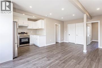 London apartment for rent - A spacious kitchen with white cabinets and a wood floor.