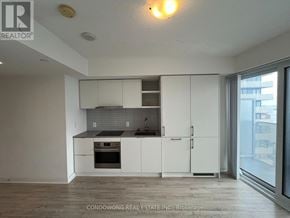 Toronto (Waterfront Communities) condo for rent - A kitchen with white cabinets and a black countertop.