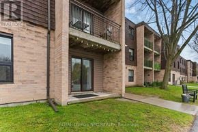 Lincoln (Beamsville) condo for rent - A building with a balcony and a sign that says REALTOR.