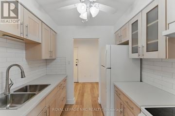 Lincoln (Beamsville) condo for rent - A kitchen with white cabinets and a white refrigerator.