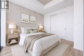 Toronto (Moss Park) condo for rent - A bedroom with a bed, nightstand, and two wall lamps.
