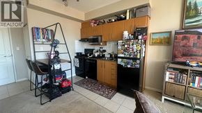 Burnaby apartment for rent - A kitchen with a refrigerator covered in magnets and a chair with a backpack on it.
