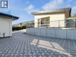 West Vancouver apartment for rent - A tiled driveway leads to a white house with a black roof.