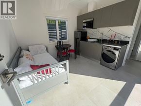 West Vancouver apartment for rent - A bedroom with a bed, a small table, and a kitchenette.