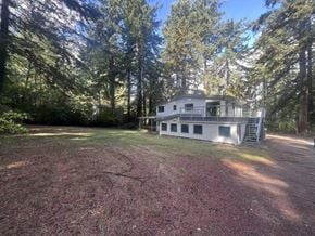 Surrey apartment for rent - A house is surrounded by trees in a wooded area.