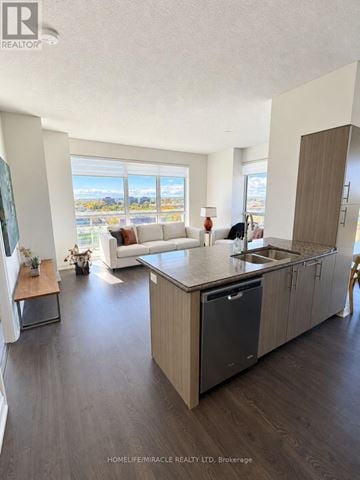 Oakville (Co Central) condo for rent - A modern kitchen with a large island and a view of the outdoors.