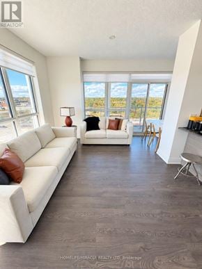 Oakville (Co Central) condo for rent - A living room with a white couch and a large window.