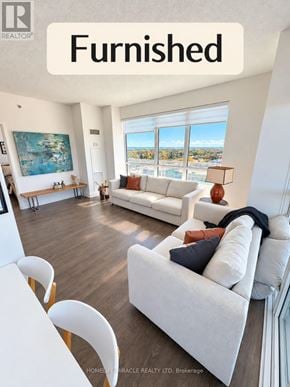 Oakville (Co Central) condo for rent - A living room with white furniture and a large window.