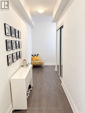 Oakville (Co Central) condo for rent - A hallway with a white wall and a yellow chair.