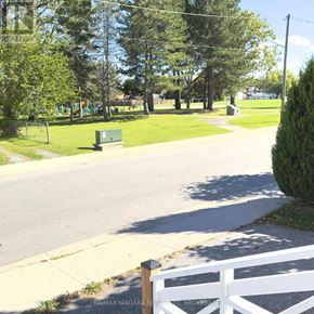 Niagara Falls (Downtown) apartment for rent - A white fence is in the foreground of a sunny day in a park.