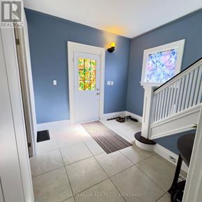 Niagara Falls (Downtown) apartment for rent - A hallway with a white door and a staircase.