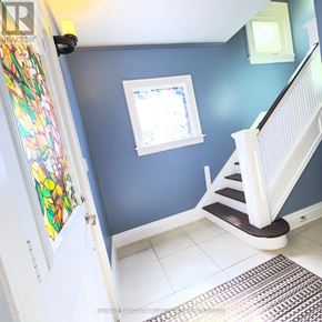Niagara Falls (Downtown) apartment for rent - A stairway with a white railing and a window on the wall.