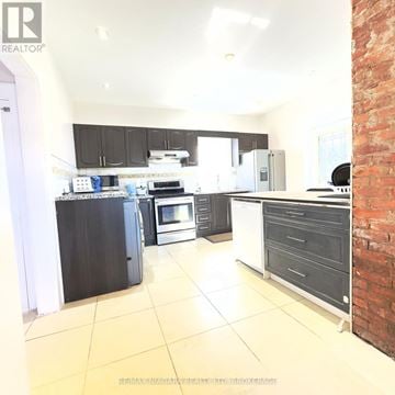 Niagara Falls (Downtown) apartment for rent - A kitchen with black cabinets and a brick wall.