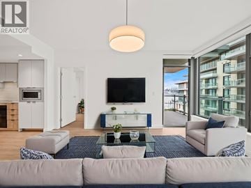 North Vancouver apartment for rent - A modern living room with a large couch and a flat screen TV.