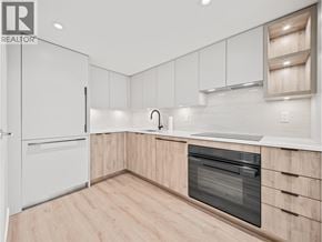 North Vancouver apartment for rent - A modern kitchen with wooden cabinets and a white fridge.
