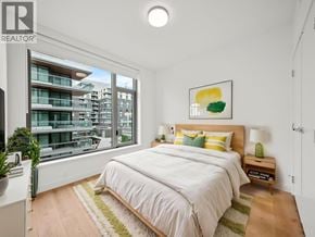 North Vancouver apartment for rent - A bedroom with a large bed and a view of a building outside the window.